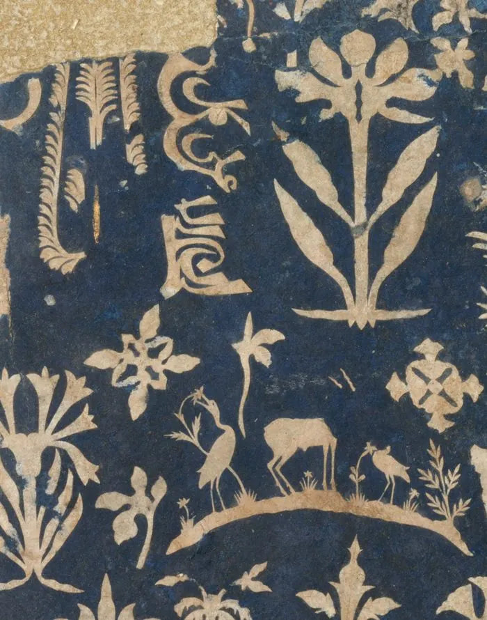 Detail of an album page: pale flowering plants cut from paper and laid on a deep indigo ground, the edges worn.